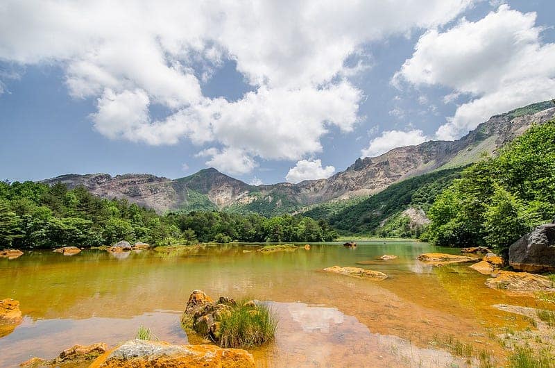 Rust and green colored Goshikinuma pond in front of Mount Bandai.