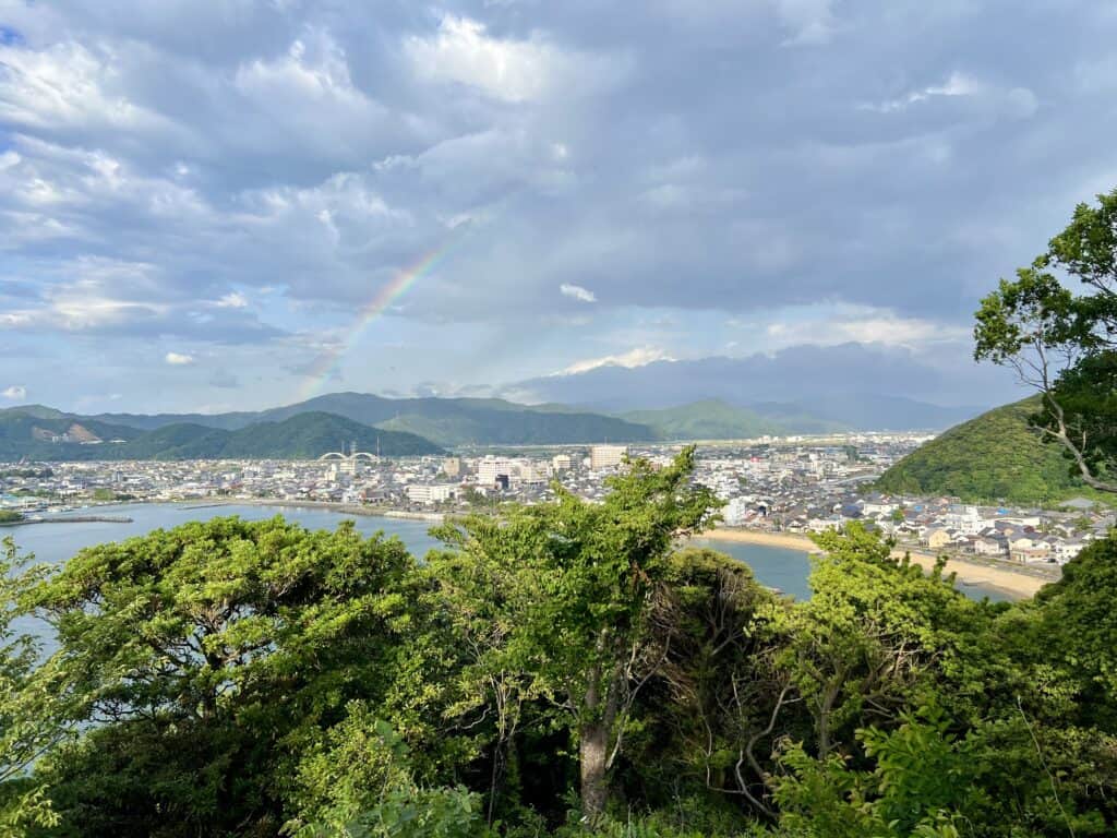 Overlooking the quiet bayside town of Obama in Fukui Prefecture, Japan. Clouds and a rainbow overhead.